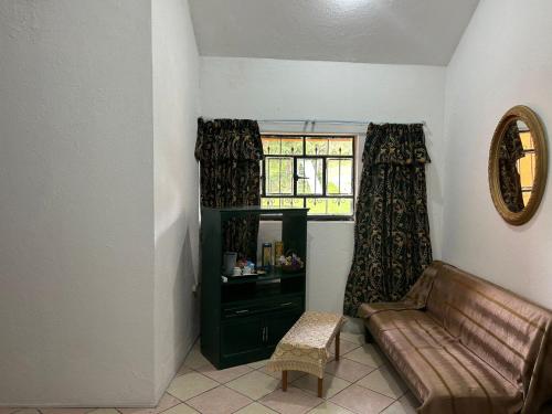 Una sala de estar con un sofá y una ventana. en Carpe Diem, en Zacatlán