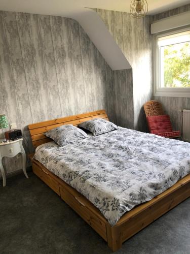 une chambre avec un lit, une fenêtre et une chaise dans l'établissement Maison de ville proche de la mer, à Le Portel