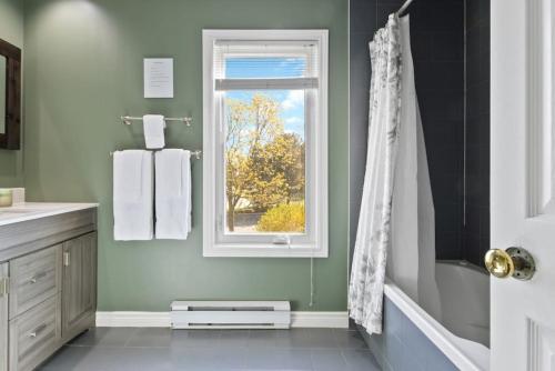 uma casa de banho com paredes verdes, uma janela e um chuveiro em 3BR Bright Mountain View Condo at Blue on Monterra em Blue Mountains