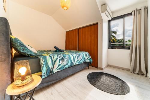 ein Schlafzimmer mit einem Bett und einem großen Fenster in der Unterkunft Le Fare de Lilizoe in Le Bois de Nèfles