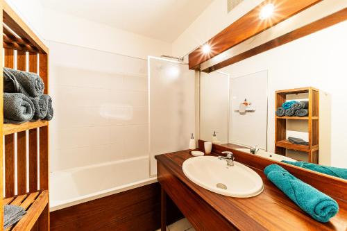 ein Badezimmer mit einem Waschbecken und einer Badewanne in der Unterkunft Le Fare de Lilizoe in Le Bois de Nèfles