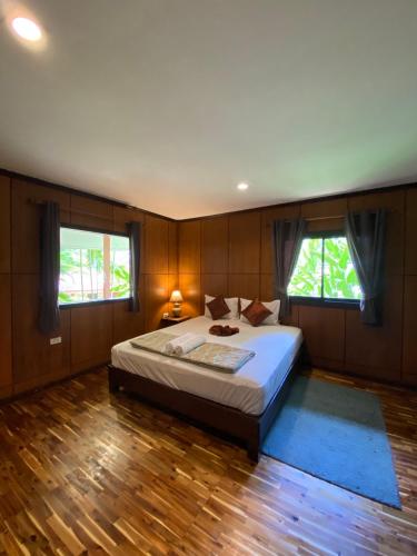 a bedroom with a large bed and two windows at Kiriraya Resort in Ao Nang Beach