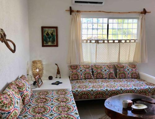 a living room with a couch and a table at Casita Colibrí - An eco chic house in Mahahual