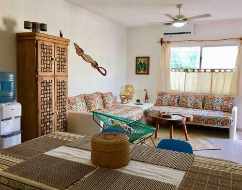 a living room with a couch and a table at Casita Colibrí - An eco chic house in Mahahual
