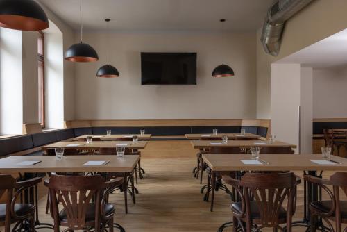 a restaurant with tables and chairs and a flat screen tv at Pivovar Rožmberk in Rožmberk nad Vltavou