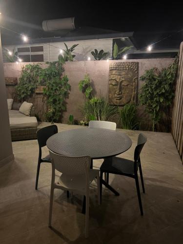 Beach side Duplex في بوناويا: طاولة وكراسي في غرفة بها نباتات