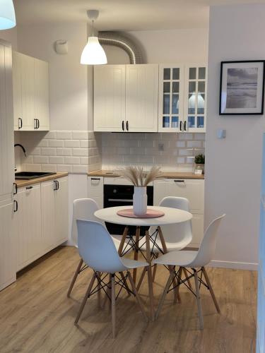a kitchen with a table and chairs in it at Letnica41 by MYPART in your apartment in Gdańsk