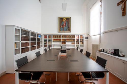 uma grande sala de conferências com uma mesa longa e cadeiras em Ostello AMDG em Veneza
