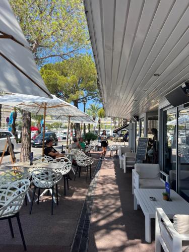 a row of tables and chairs with people sitting at them at Studio marina baie des anges in Villeneuve-Loubet