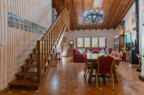 ein Wohnzimmer mit einer Treppe, einem Tisch und Stühlen in der Unterkunft Zafiro lagunazo Riopar 5 Dormitorios 3 Baños Parque Natural del Rio Mundo in Riópar
