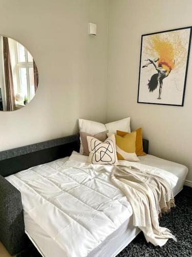 białe łóżko w pokoju z lustrem w obiekcie Modern and cozy studio apartment in central Oslo w Oslo
