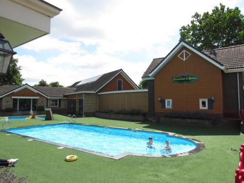 un grupo de personas jugando en una piscina en HderH - Eco Lodge op vakantiepark De IJsvogel, zwembaden, kids fun, natuur en rust, en Voorthuizen