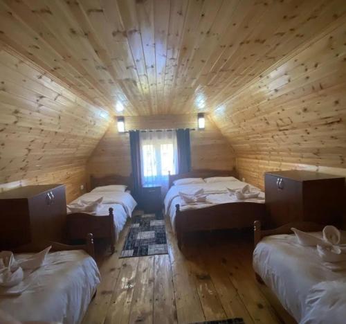 Habitación con 3 camas en una cabaña de madera en HIGHLANDER HOUSE VERMOSH, en Vermosh