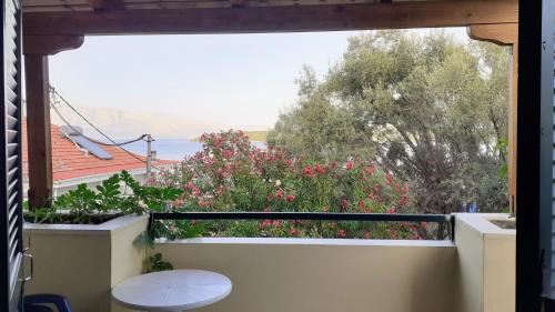 a balcony with a view of a garden with flowers at Hotel Niras in Nydri