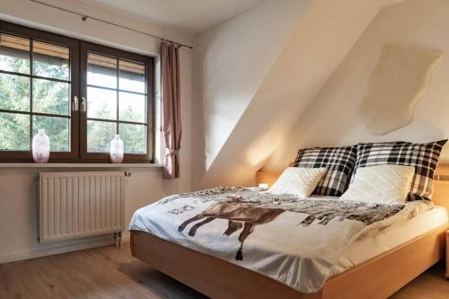 a bedroom with a bed and a window at Das Waldseechalet Märchenhafter Waldseeblick - moderne Wohnung mit Infrarotsauna in Hasselfelde