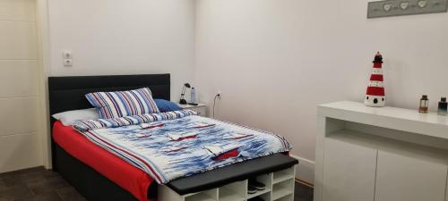 ein kleines Schlafzimmer mit einem Bett und einem Leuchtturm darauf in der Unterkunft IQBAL-Hütte FeWo Appartement - Ankerplatz in Beverstedt