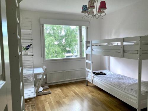 1 dormitorio con literas, escritorio y ventana en 2 br apartment w/ balcony, wifi, parking, en Espoo