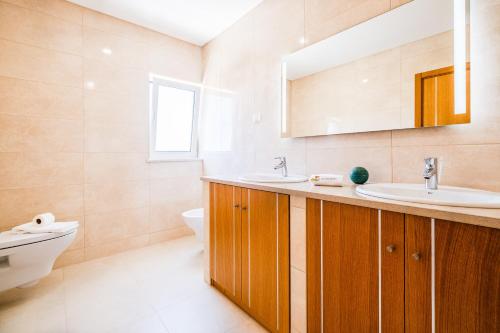 a bathroom with two sinks and a toilet at Villa Impasse - Albufeira in Albufeira