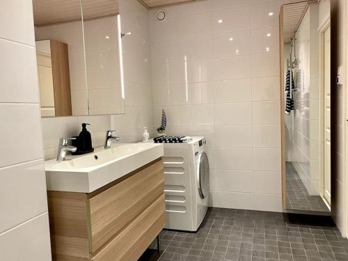 y baño con lavabo y lavadora. en 2 br apartment w/ balcony, wifi, parking, en Espoo