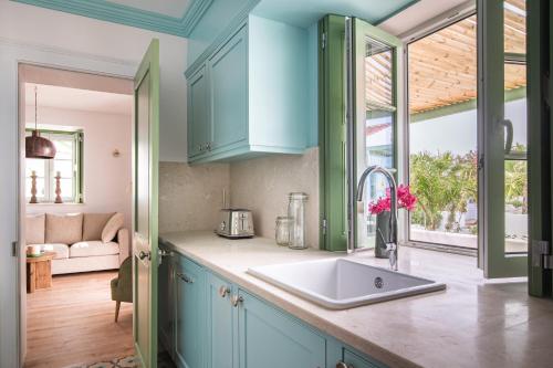 una cocina con armarios azules y fregadero en The Green House Alentejo by Santiago de Alfama, en Vila Nova da Baronia