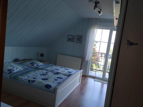 Schlafzimmer mit einem Bett und einem Fenster in der Unterkunft Dom Baltyk in Gąski