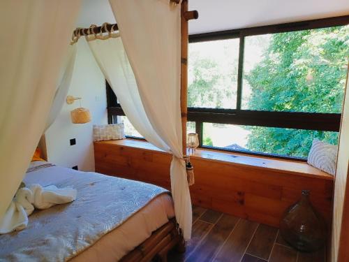 1 dormitorio con cama y ventana grande en Le Moulin de l'Asse Chambre d'Hôtes, en Bras-dʼAsse