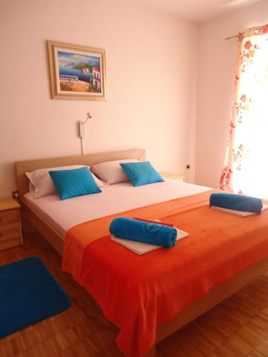 a bedroom with two beds with blue pillows on them at Guesthouse Lisica in Petrcane