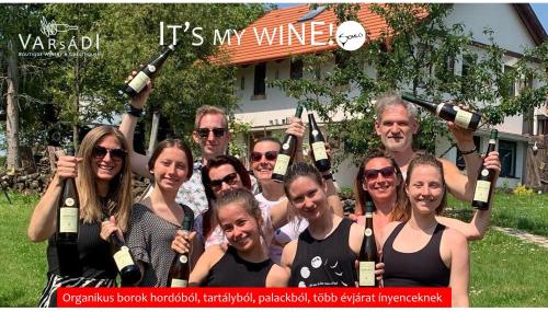 a group of people posing for a picture with bottles of wine at Juhfark Apartman Varsádi Wineyard in Somlóvásárhely