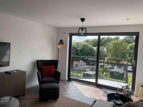 a living room with a chair and a large window at ROOMZ TOWNHOUSE NO 20 in Portaferry