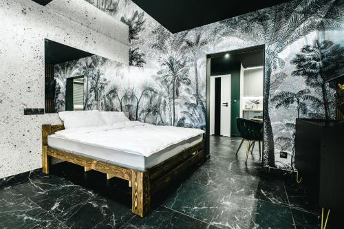 a bedroom with a bed with a tropical wallpaper at Złota Grota 