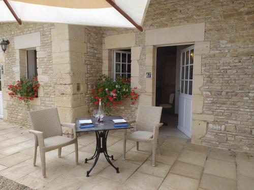 une table et des chaises assises sur une terrasse dans l'établissement Chambres Résidentielles avec cuisine au Manoir de Mathan à Crépon 5 mn D'Arromanches et 10 mn de Bayeux, à Crépon