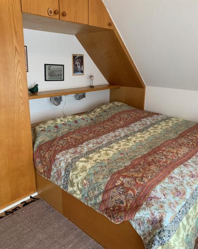 a bed in a room with a wooden bed frame at Ferienwohnung Apfelrose in Oldsum