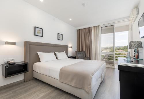 a hotel room with a large bed and a window at Hotel Do Parque - Congress & SPA in Termas de Sao Pedro do Sul