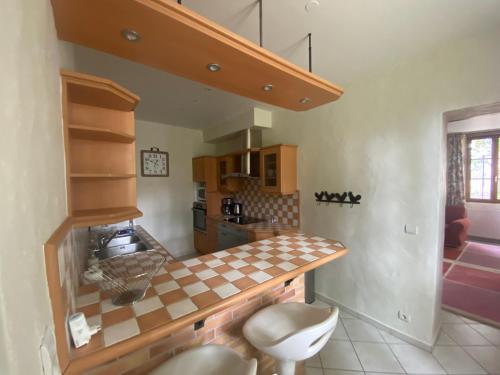 - une cuisine avec un comptoir en damier dans la chambre dans l'établissement Pavillon d’entrée du château de Bouesse, à Bouesse