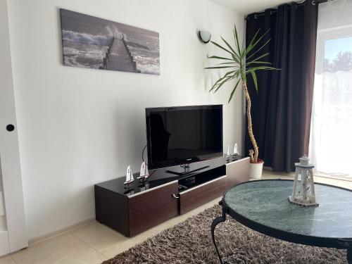 a living room with a tv and a coffee table at Villa Upwind in Osłonino