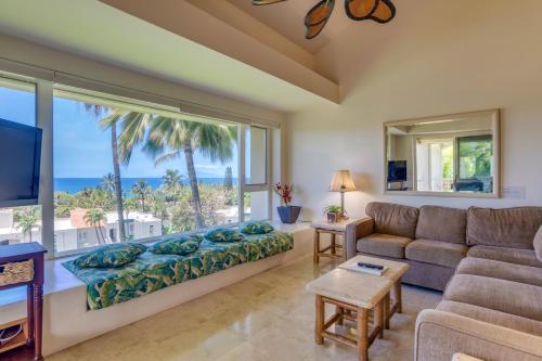 a living room with a couch and a large window at Palms at Wailea in Wailea