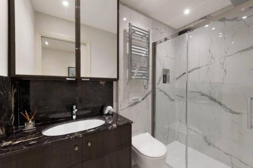 a bathroom with a sink and a toilet and a shower at Wonderful Knightsbridge Apartment by Harrods in London