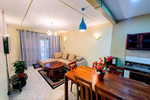 ein Wohnzimmer mit einem Tisch und einem Sofa in der Unterkunft Peace of Mind Suites in Entebbe