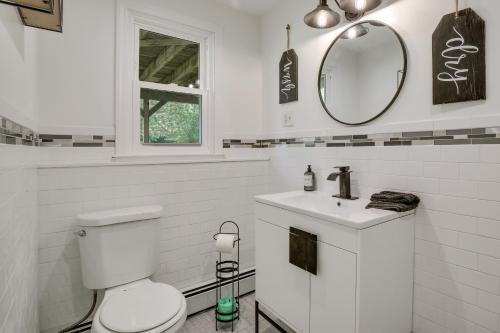 een witte badkamer met een toilet en een spiegel bij Marlboro Vacation Rental with Fire Pit and Yard! in Marlboro