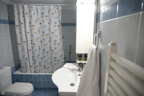 een badkamer met een wastafel, een toilet en een douchegordijn bij ILOS APARTMENT in Nafplio