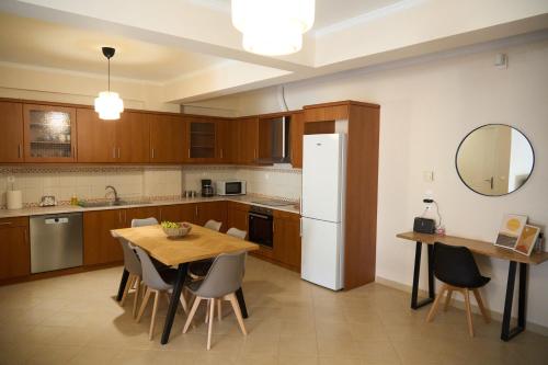 een keuken met een tafel en een witte koelkast bij ILOS APARTMENT in Nafplio