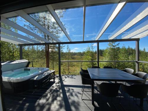 a patio with a hot tub and a table and chairs at Northern Light Villa Ylläs with a Jacuzzi in Ylläsjärvi
