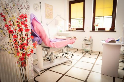 a dental room with a chair and a mirror at Hotel Anek in Mrągowo