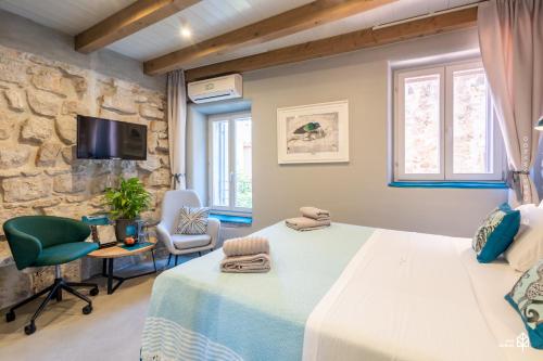 sypialnia z dużym łóżkiem i kamienną ścianą w obiekcie Casa Amando Eco Boutique House w Rovinj