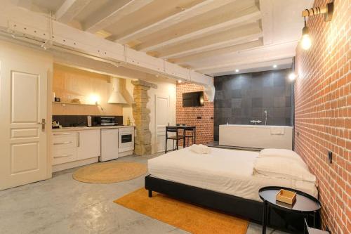 une chambre avec un lit et un mur de briques dans l'établissement Industrial-style studio with bathtub, Vieux-Lyon, à Lyon