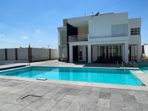 a swimming pool in front of a house at Casa Girasol in Oaxtepec