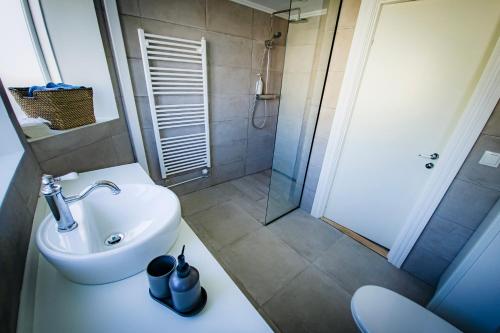 a bathroom with a white sink and a shower at Guesthouse Holl in Vestmannaeyjar