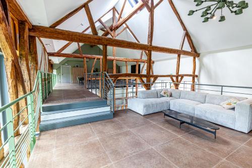 ein Wohnzimmer mit einem Sofa und einer Treppe in der Unterkunft Hameau des 40 arpents in Gergy