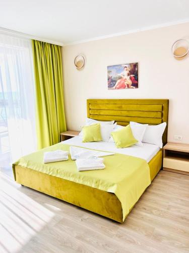 a bedroom with a large bed with yellow sheets at KIR House On The Beach in Eforie Nord