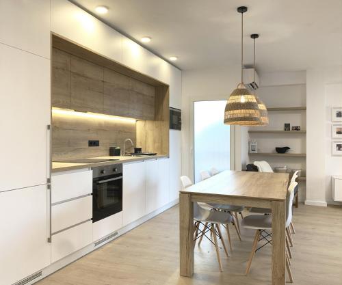 een keuken met een houten tafel en witte kasten bij Apartamento de 3 habitaciones a 100 m de la playa del Arenal, Javea in Platja de l'Arenal
